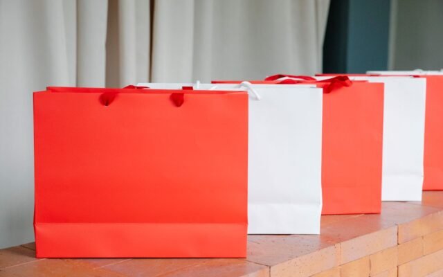 Sacs de shopping rouges et blancs sur un comptoir, pour un achat de maillot de bain en urgence à Aqualibi