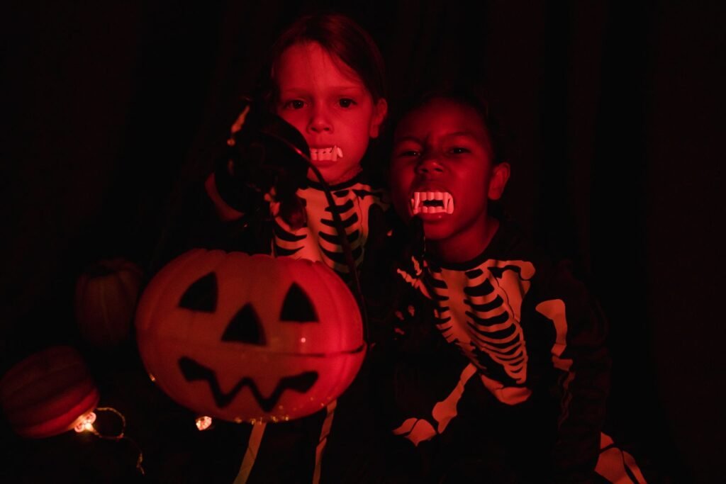 Enfants déguisés en squelettes avec de fausses dents de vampire, Halloween et zones ados à Plopsaland