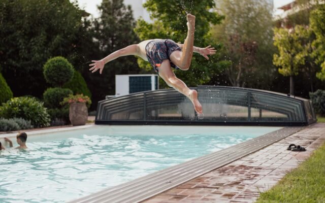 Garçon qui saute dans une piscine de jardin, idée d Airbnb avec piscine près de Plopsaland