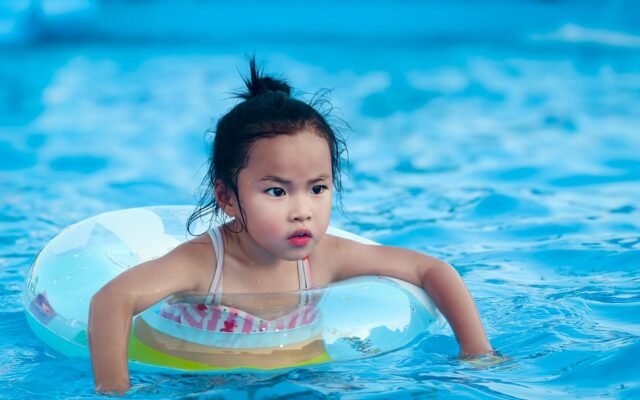 Petite fille avec une bouée dans une piscine, profitant d'un Aqualibi pass illimité