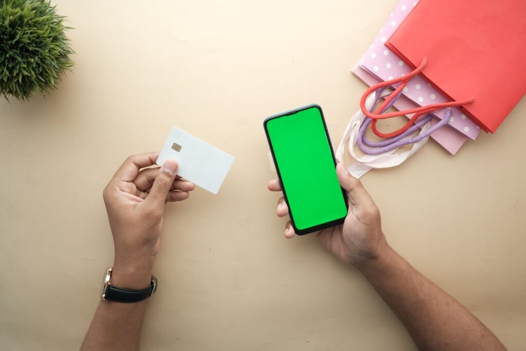 Mains avec smartphone et carte pour utiliser un code promo Plopsaland Le Vif