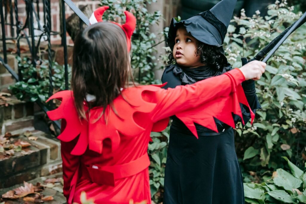 Deux enfants déguisés en diable et en sorcière en extérieur, règles de déguisement dans les parcs à Halloween