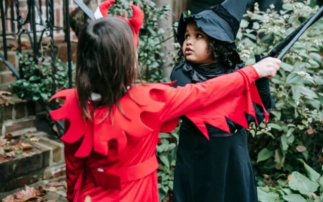 Deux enfants déguisés en diable et en sorcière en extérieur, règles de déguisement dans les parcs à Halloween