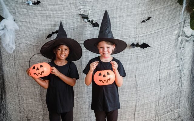 Deux filles souriantes en costume de sorcière avec des citrouilles, Halloween en famille aux Pays-Bas
