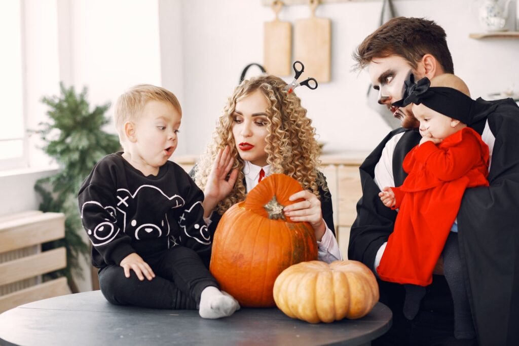 Famille déguisée qui décore des citrouilles, Halloween en famille à Plopsaland De Panne