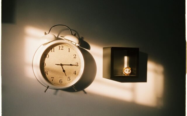 Réveil vintage au mur dans la lumière du soleil, horaires de Plopsaland De Panne