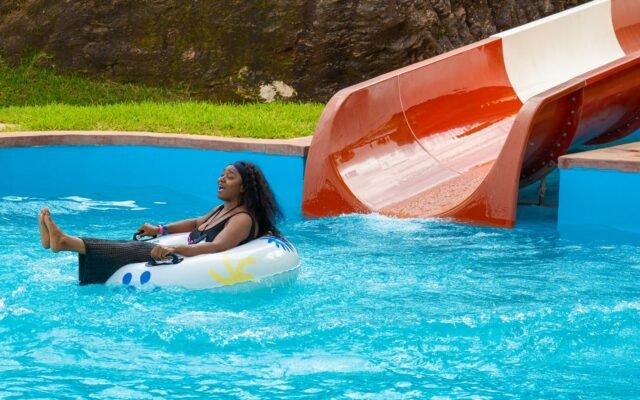 Femme détendue sur une bouée au bas d'un toboggan, après avoir présenté son billet Aqualibi imprimé ou sur smartphone