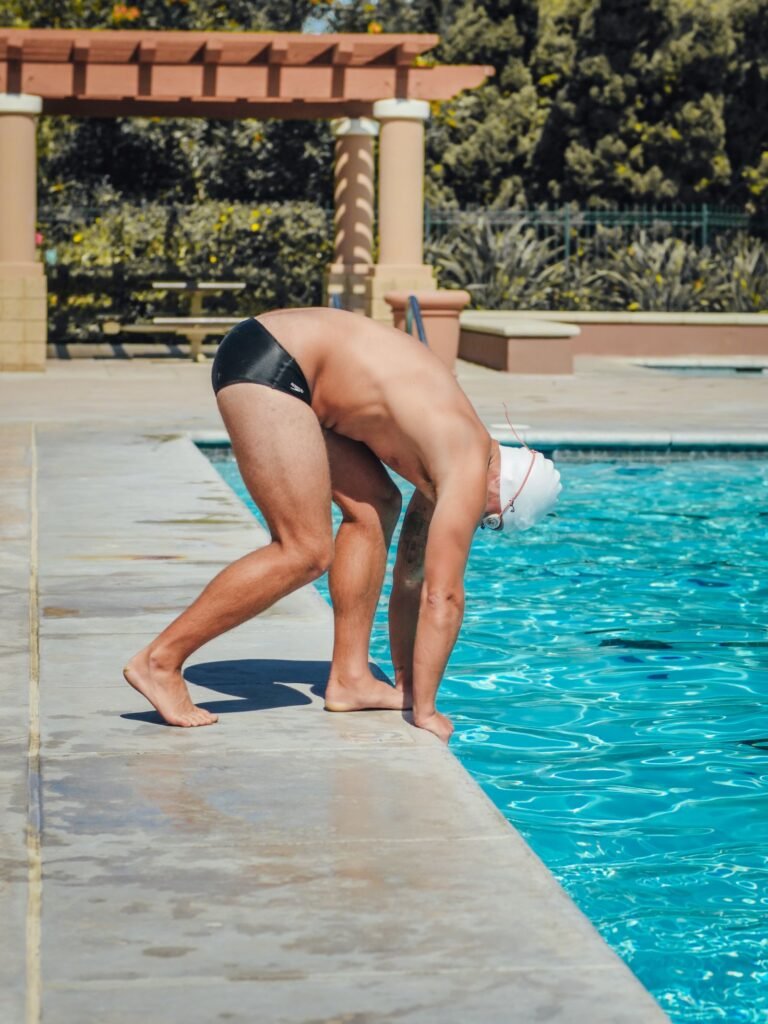 Homme en slip de bain qui plonge dans une piscine, avec une matière de maillot autorisée à Aqualibi
