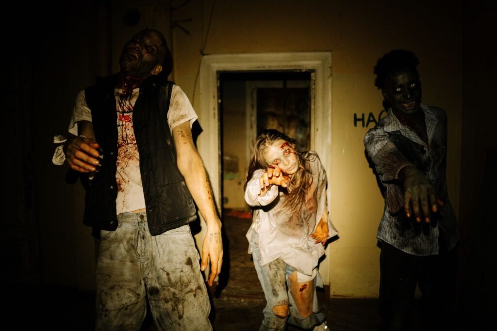 Trois zombies déguisés tendent les mains dans une maison abandonnée, parc le plus effrayant pour Halloween
