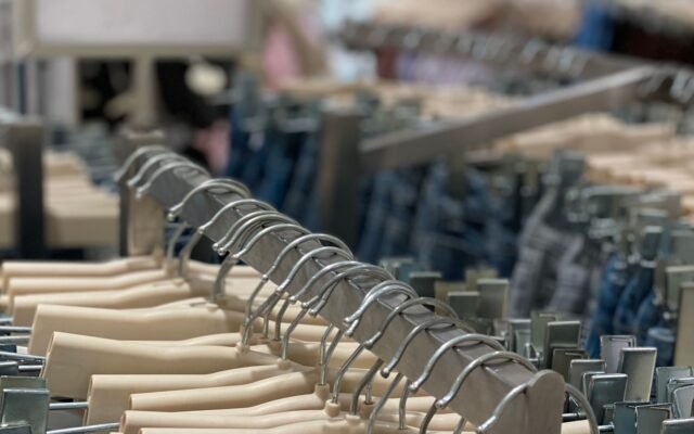 Vêtements sur des cintres dans un magasin, pour comparer le prix d'une location de bain à Aqualibi