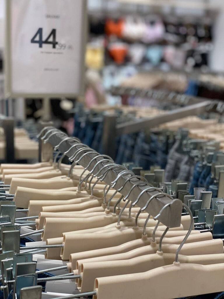 Vêtements sur des cintres dans un magasin, pour comparer le prix d'une location de bain à Aqualibi