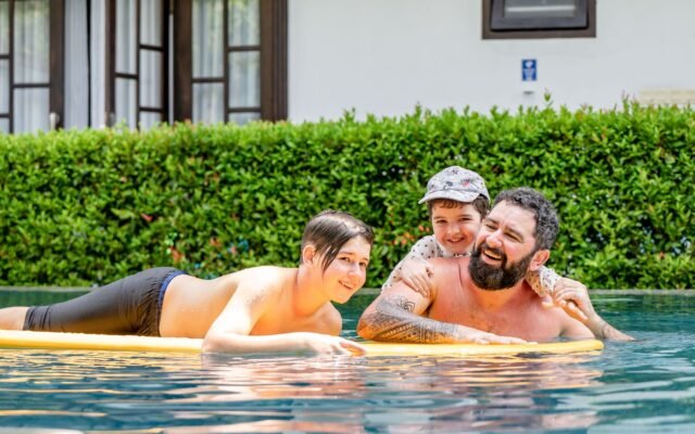 Famille souriante dans une piscine, pour qui la météo ne change rien au billet Aqualibi