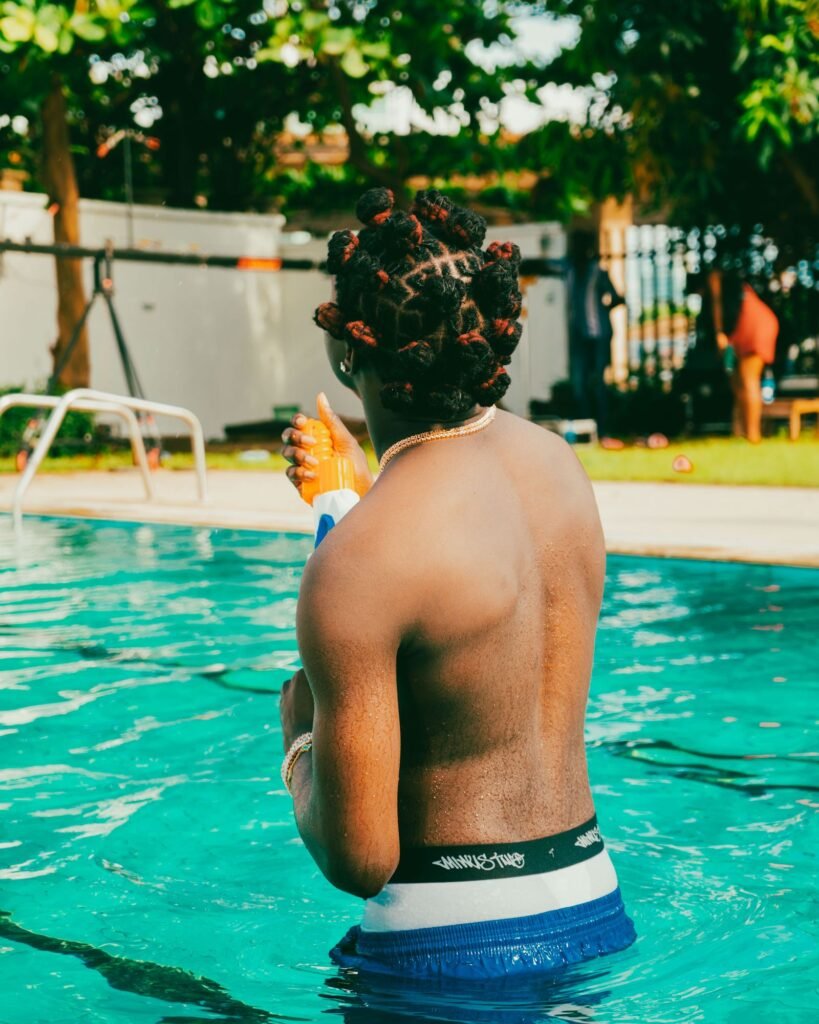 Jeune homme dans une piscine en boxer de bain, l'alternative autorisée au short de bain à Aqualibi